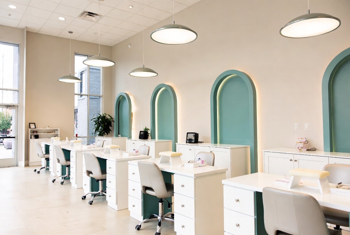 Clean, modern nail salon interior with teal-accented manicure stations